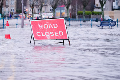 A road closed sign on a flooded road