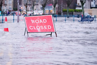 A road closed sign on a flooded road