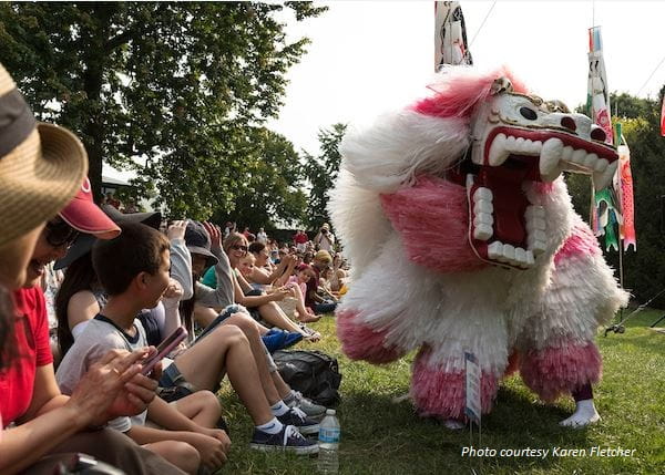 A crowd enjoys a dragon dance performed at the Missouri Botanical Garden's Japanese Festival.